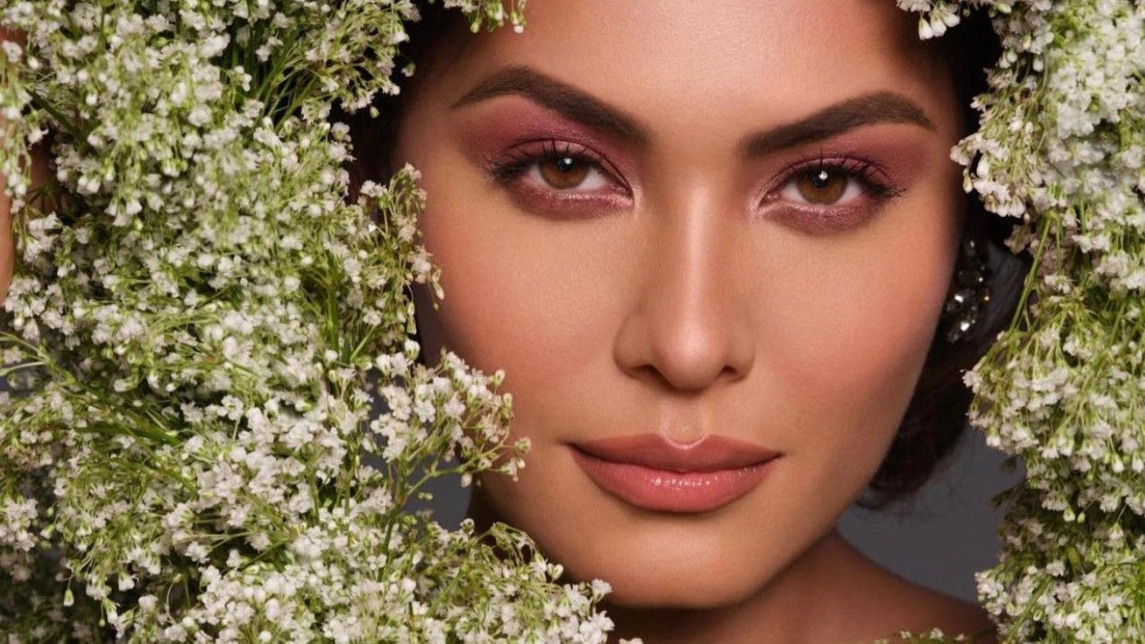 Andrea Meza posing amongst flowers for Miss Beauty Mexico