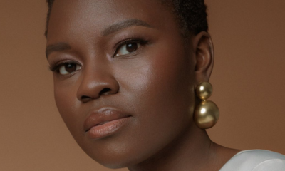 Shaunette Renee Wilson in gold ball earrings against a brown background