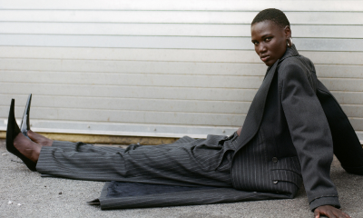 Model sits on pavement wearing Ben-Amun earrings and oversized suit
