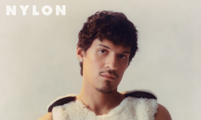 Omar Apollo wearing fuzzy white vest and Ben-Amun pin for Nylon