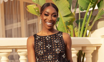 Ego Nwodim wears crystal earrings from Ben-Amun and a black dress with white flowers and feathers