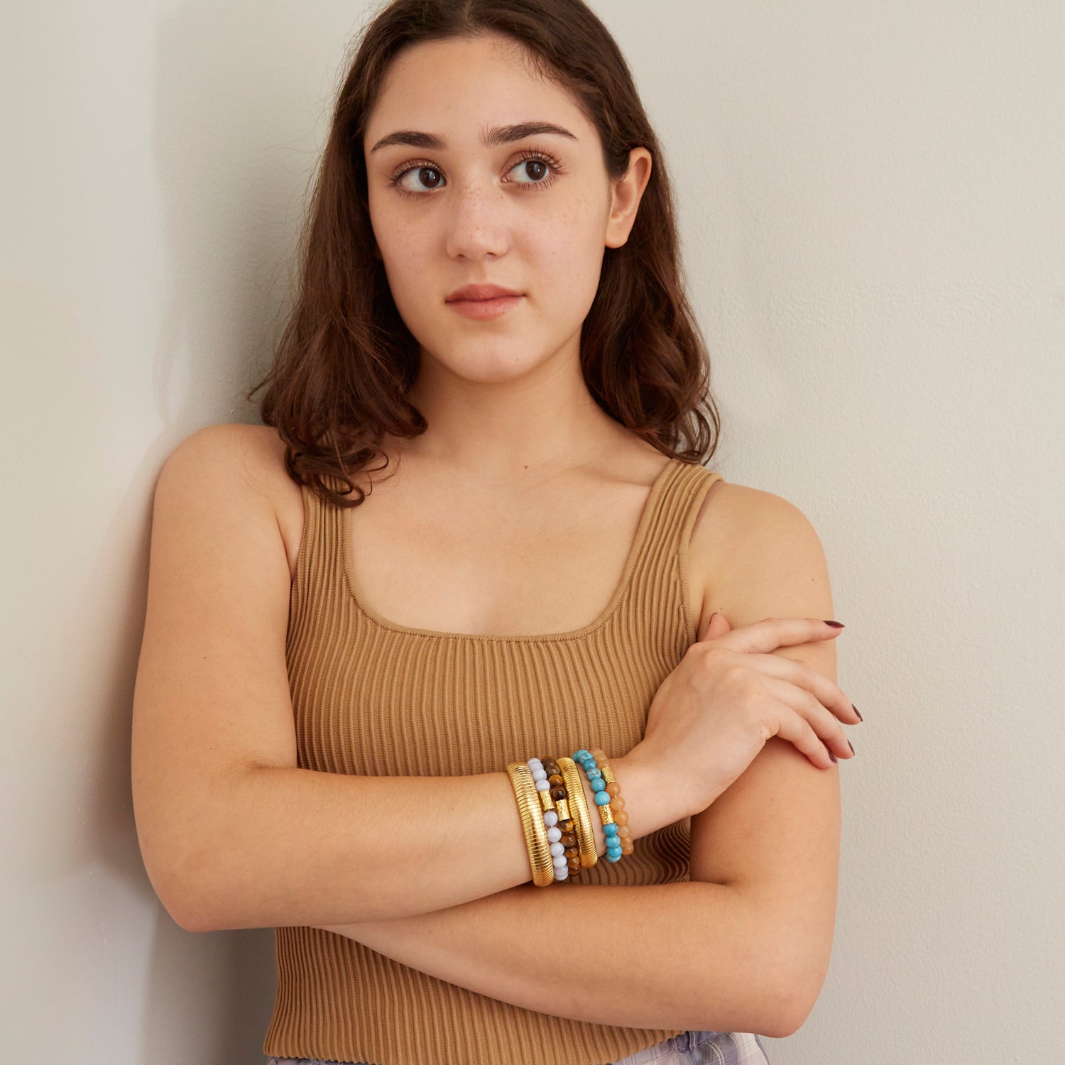 woman wearing gold bangles and colorful beaded bracelets 