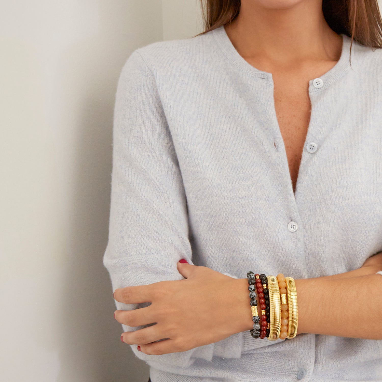 woman wearing gold bangles and colorful beaded bracelets