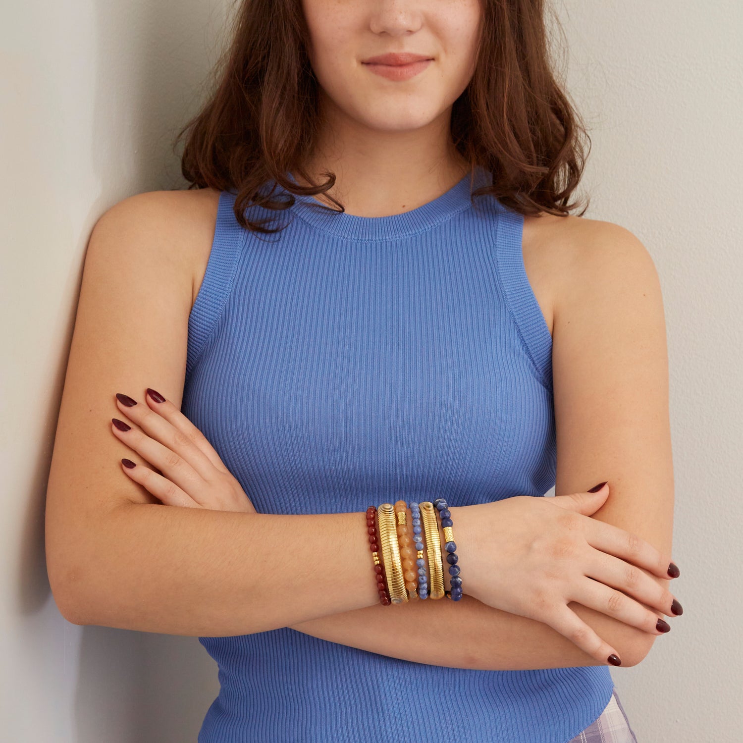 woman wearing gold bangles and colorful beaded bracelets