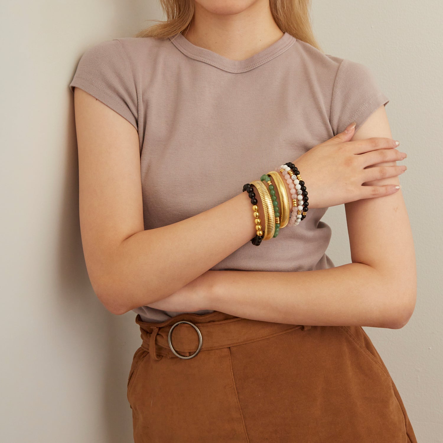 woman wearing gold bangles and colorful beaded bracelets