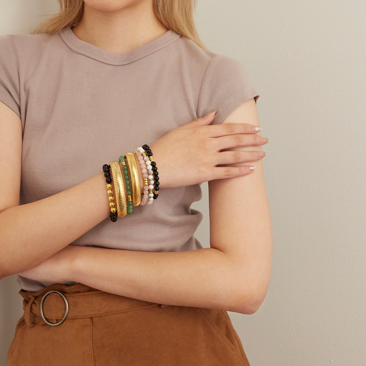 woman wearing gold bangles and colorful beaded bracelets