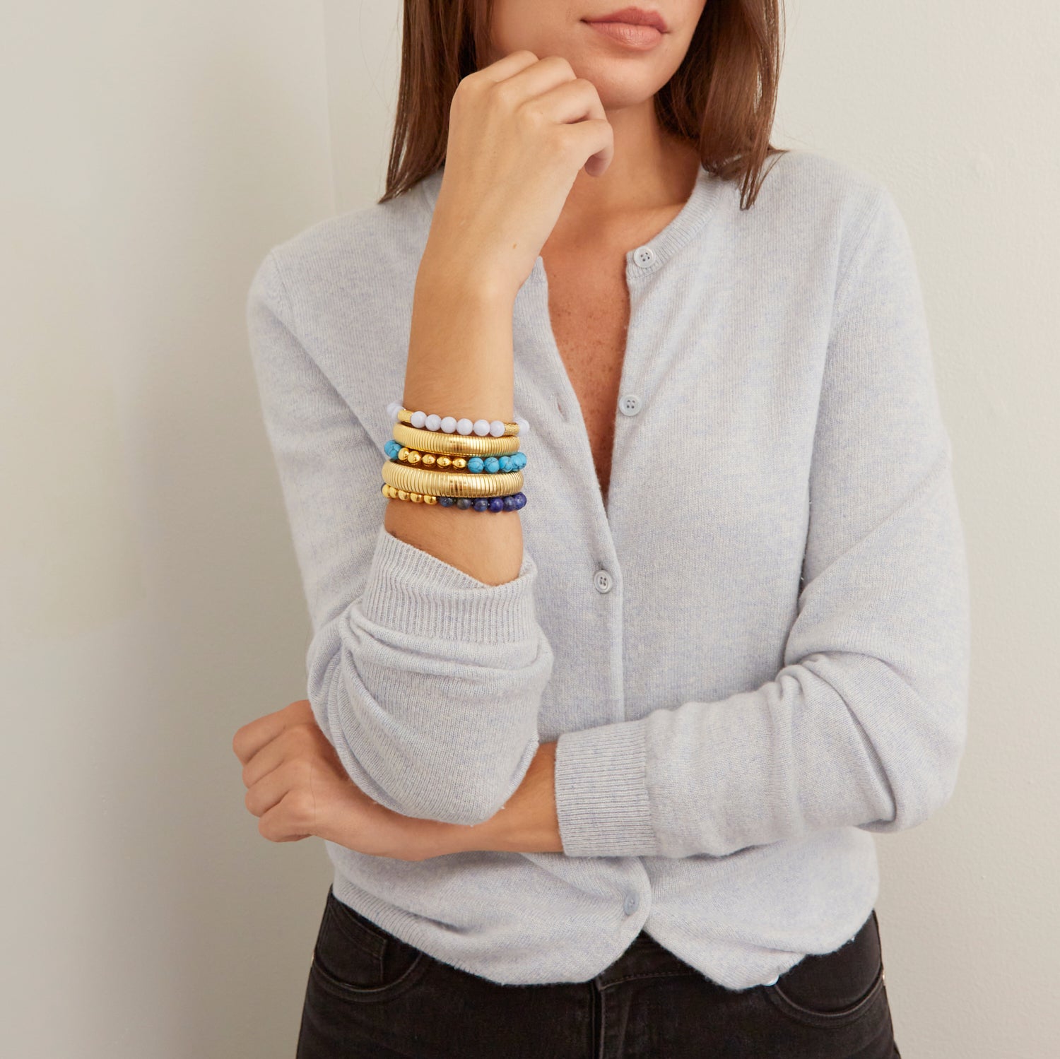 woman wearing gold bangles and colorful beaded bracelets