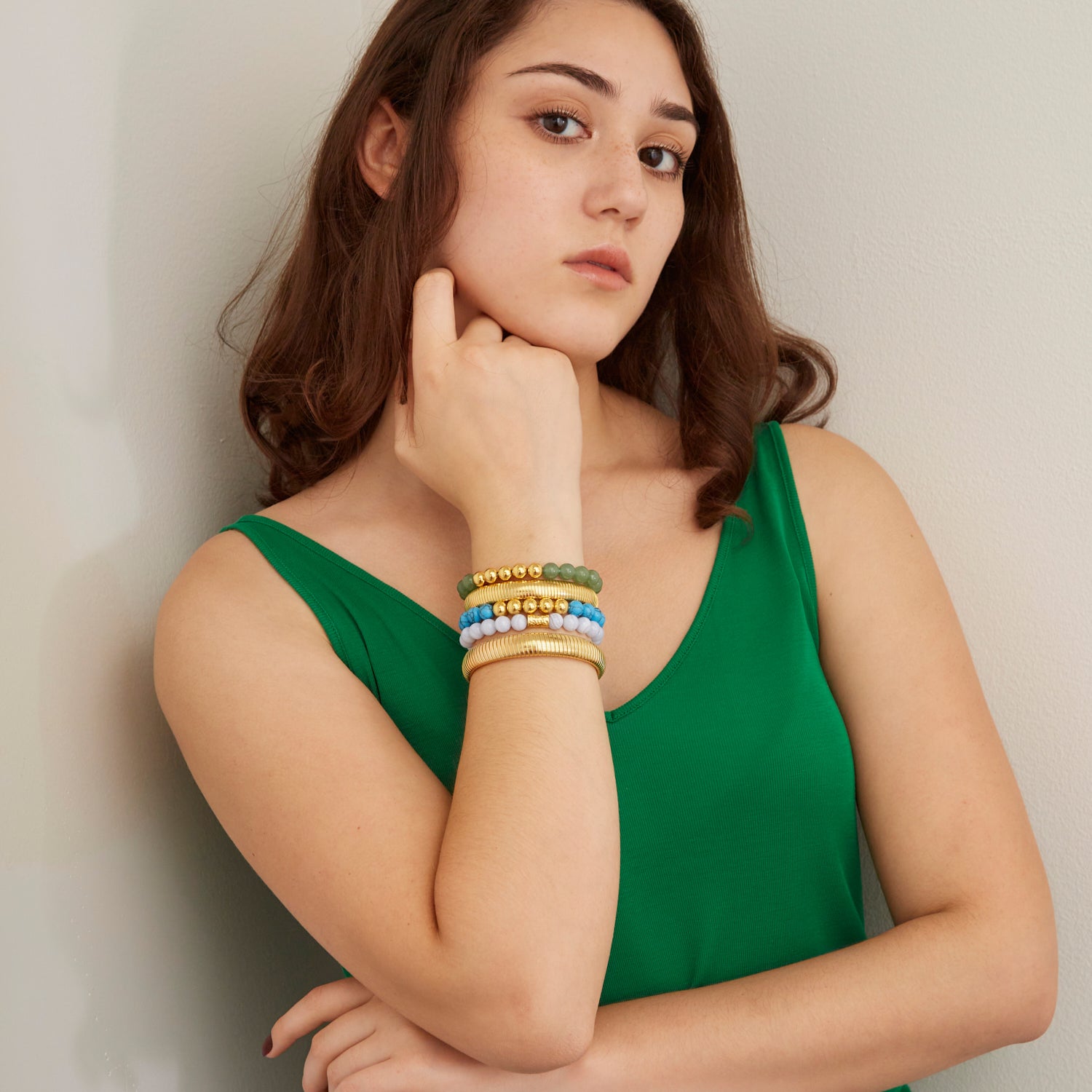 woman wearing gold bangles and colorful beaded bracelets