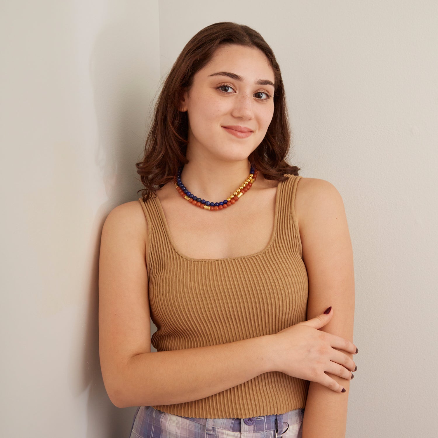 woman in tan tank top wearing blue and orange beaded necklace