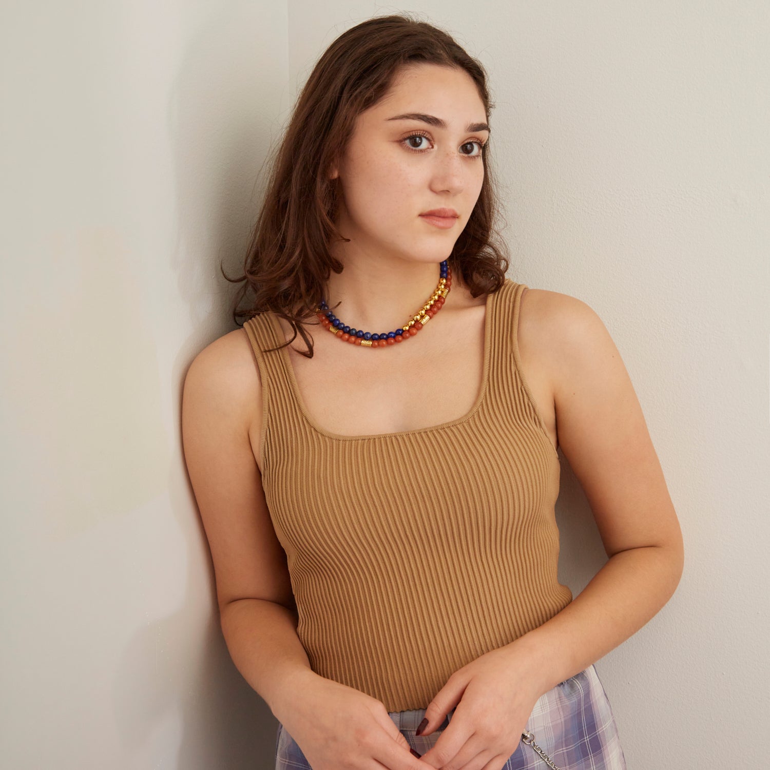 woman in tan tank top wearing blue and orange beaded necklace
