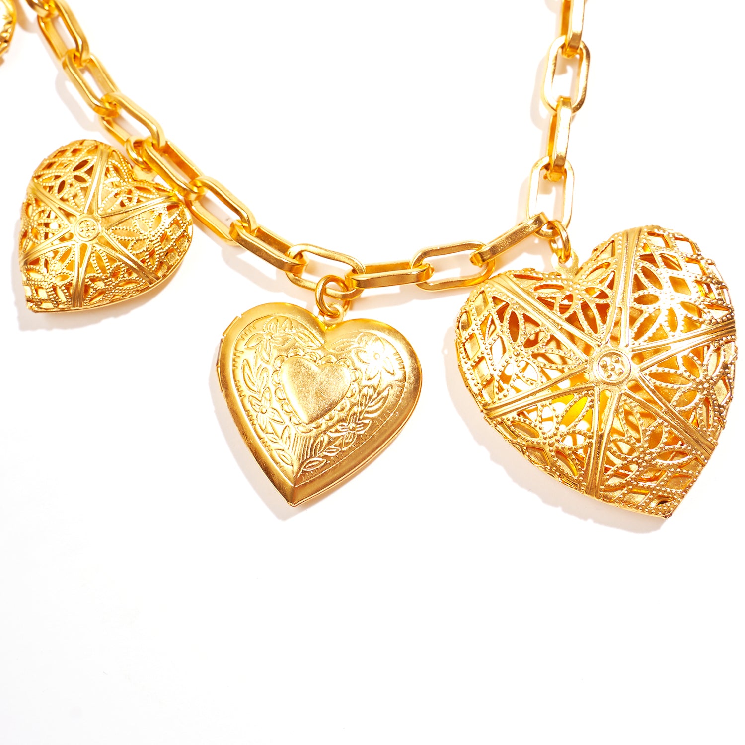 close up of gold statement necklace with engraved heart lockets