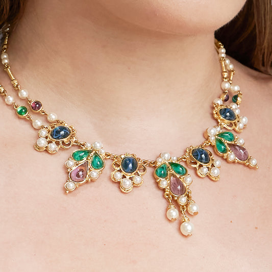 close up of model wearing Ben-Amun gold necklace adorned with gemstones and pearls