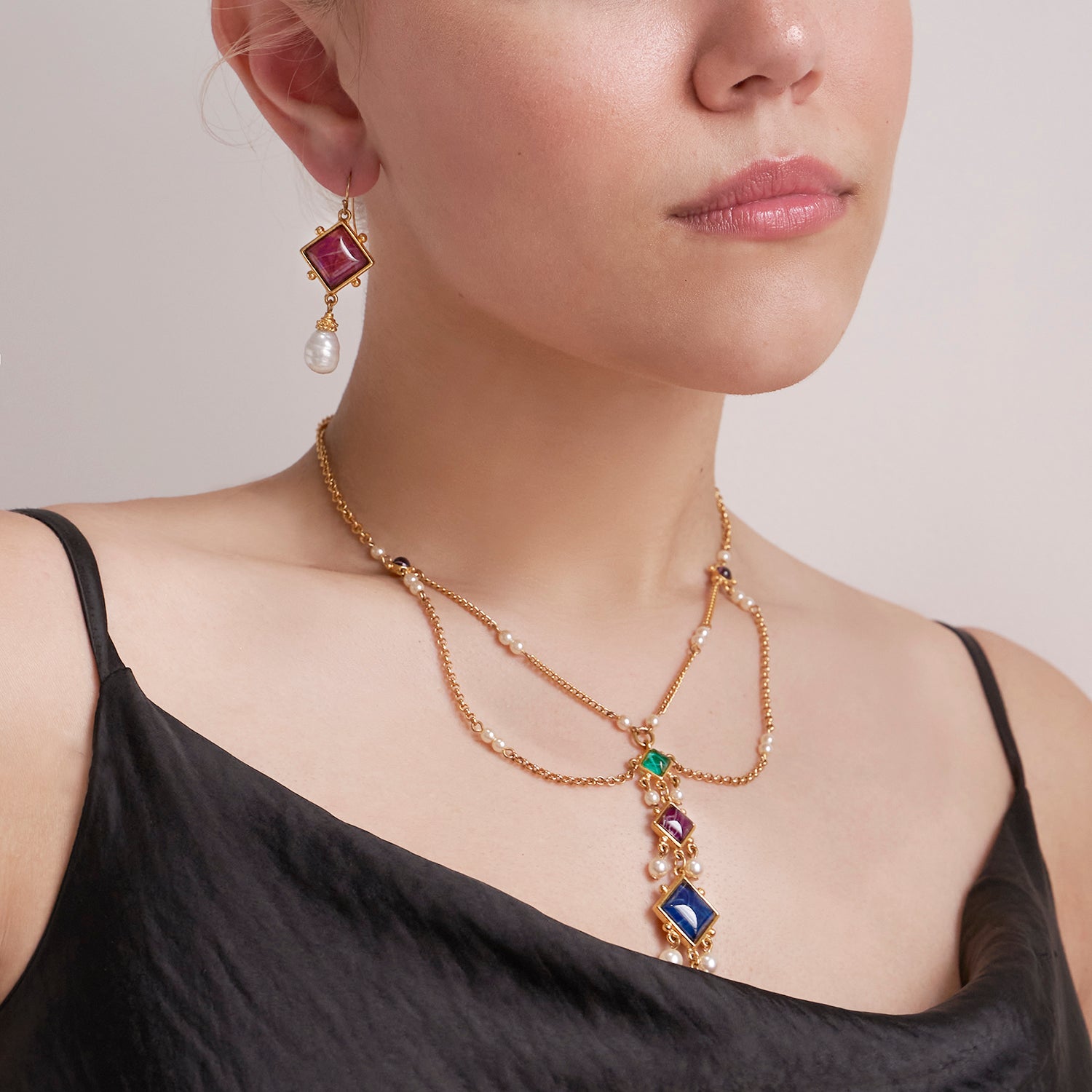 model wearing gold fish hook earring and gold necklace adorned with majorca pearls and czech glass stones