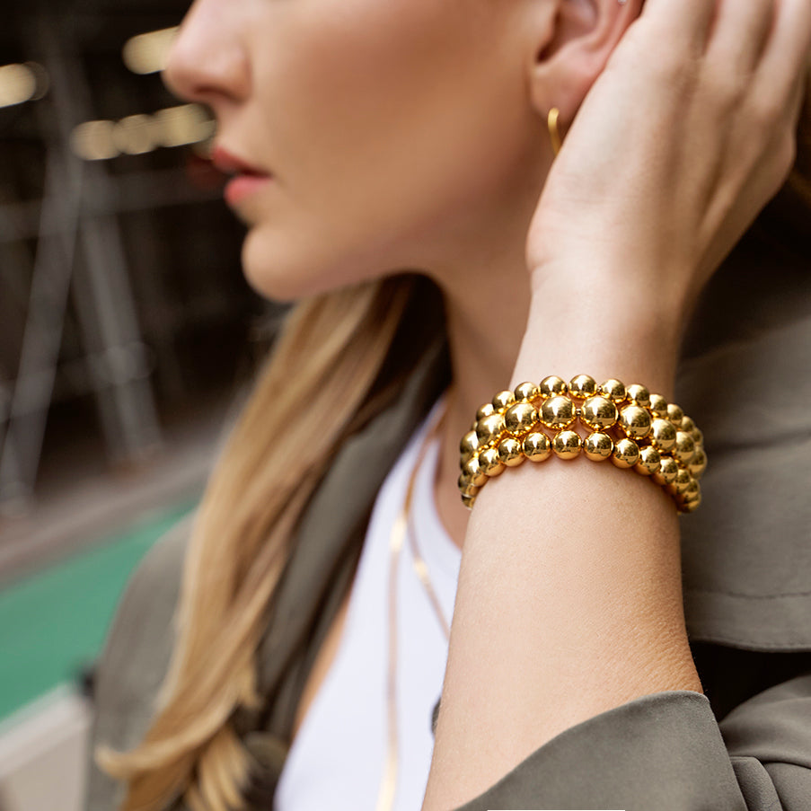 Model styled with Ben-Amun three layer gold ball bracelet  and gold earring