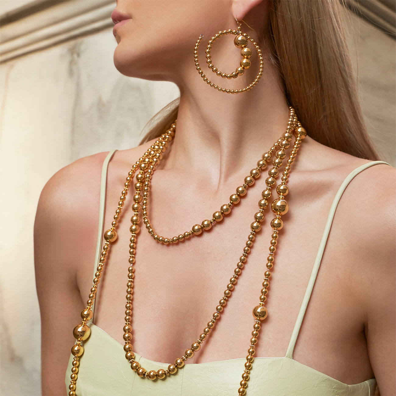 Model wearing Ben-Amun ball necklace with gold ball earrings