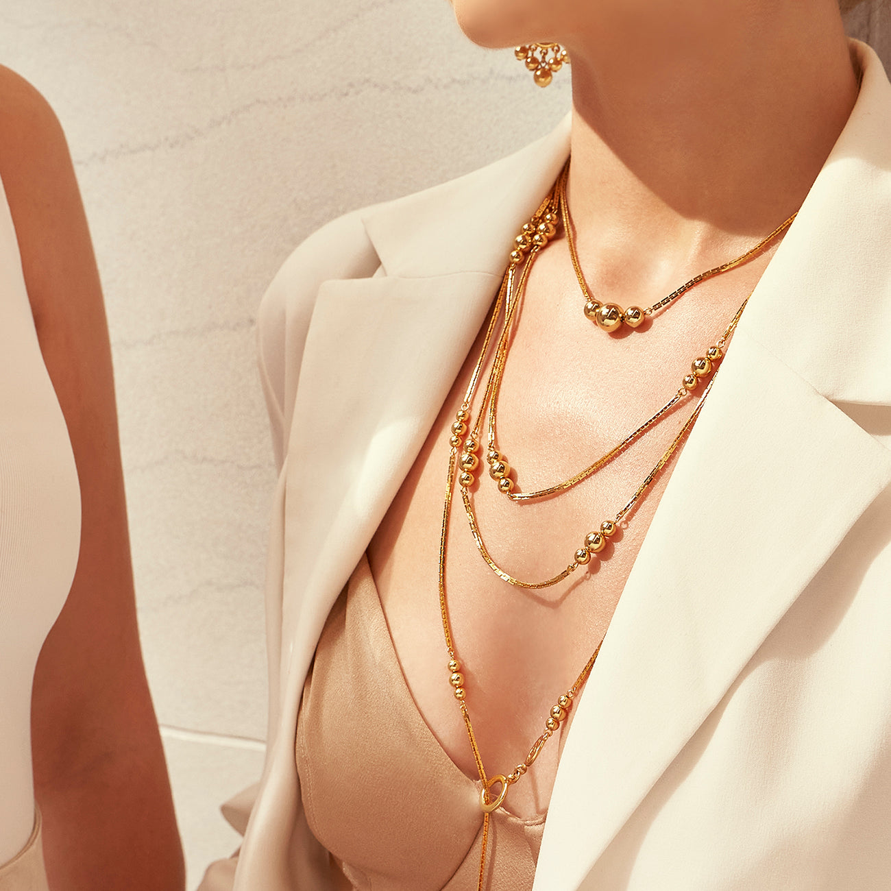 model wearing two Ben-Amun gold statement necklaces
