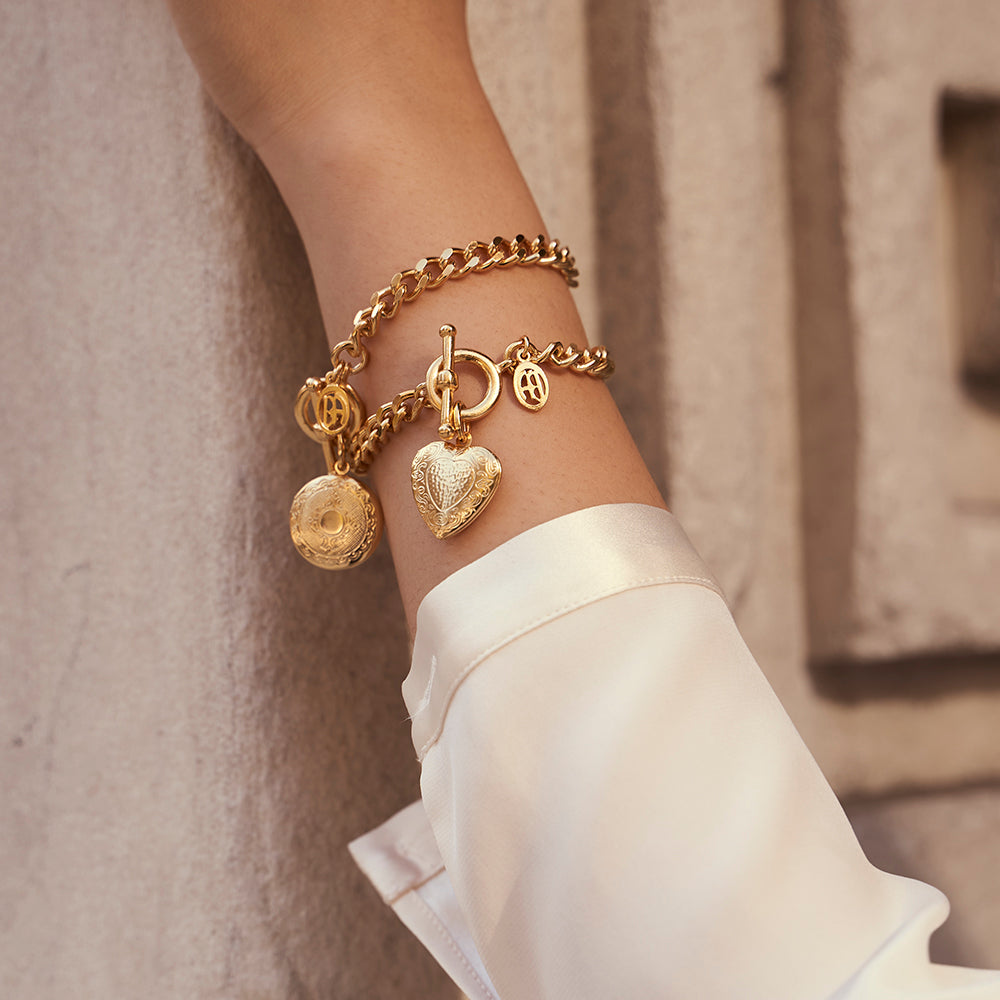 model wearing two gold charm bracelets 