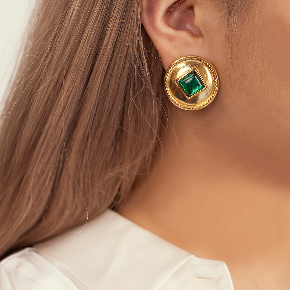 model wearing circular gold clip on earrings 