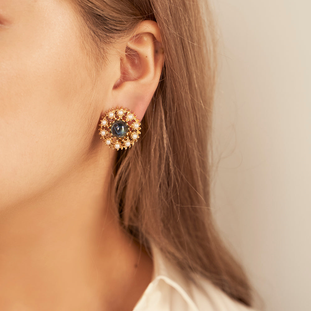 model wearing gold, gemstone and pearl clip on earrings