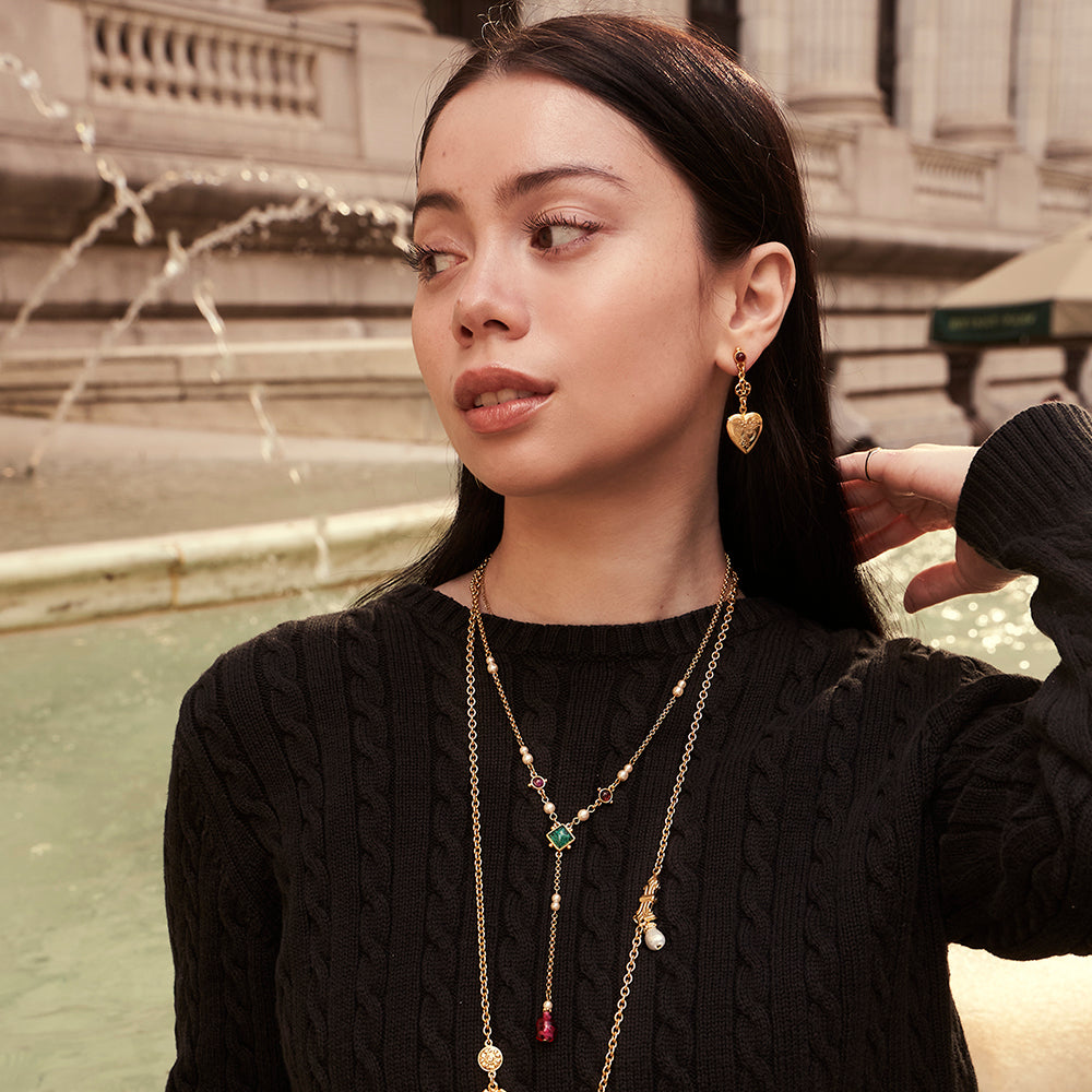 model wearing gold drop necklace, long necklace, and heart shaped locket earrings with majorca pearls and czech glass stones