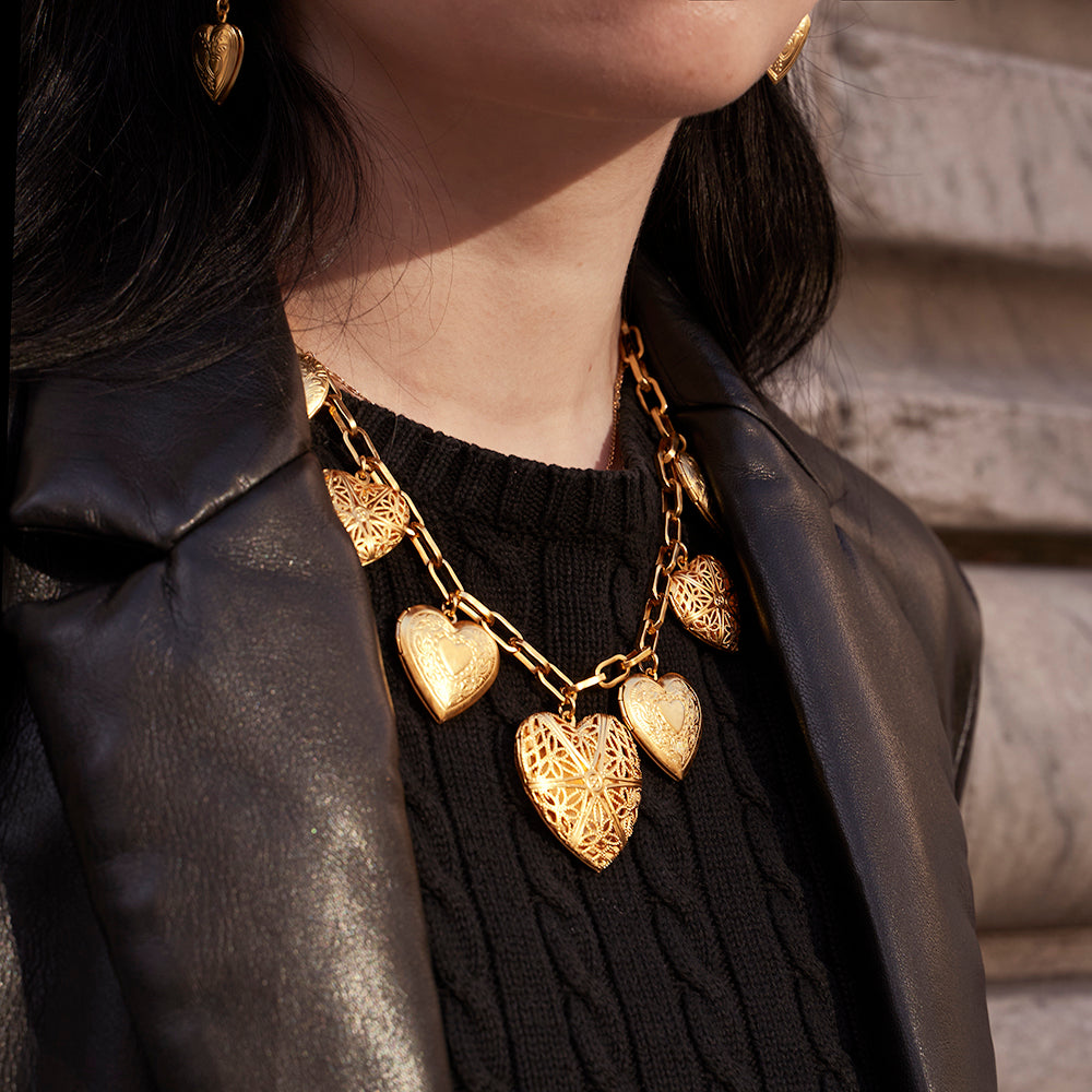 model styled with heart shaped locket earrings and chain link necklace with multiple heart lockets
